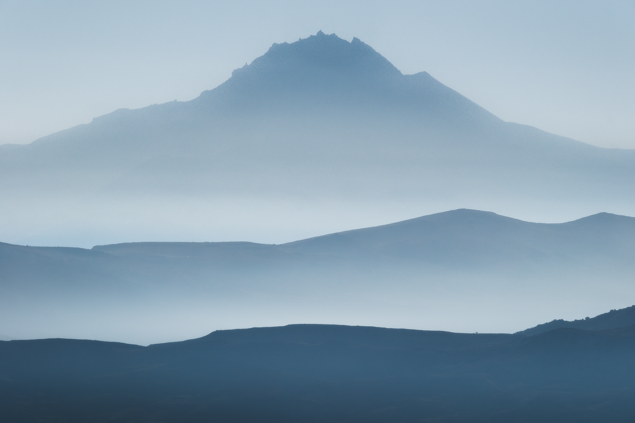 Layered mountain silhouettes fading into blue atmospheric haze near Cappadocia