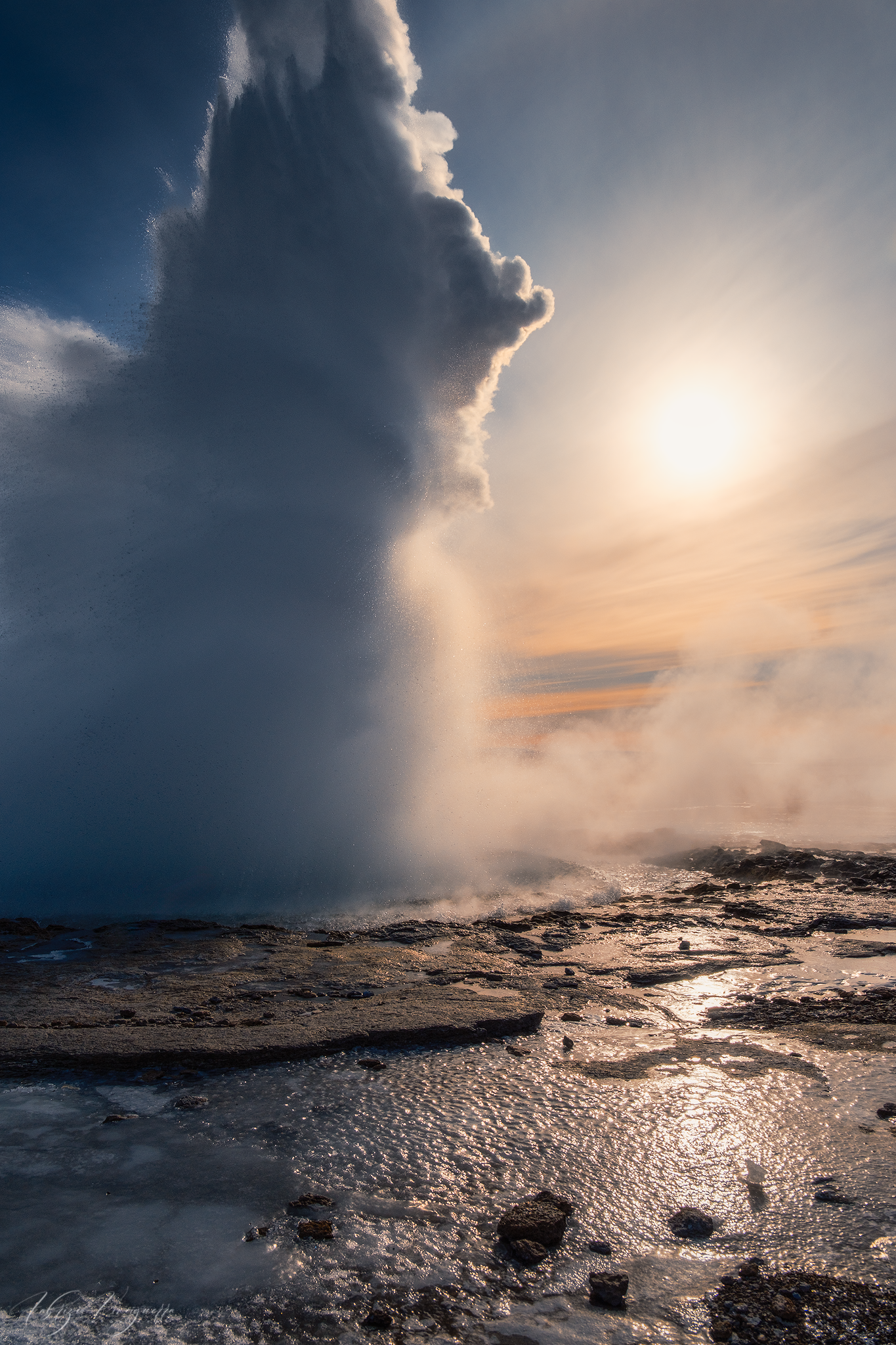 Sunlight breaking through a dramatic storm cloud above the Icelandic landscape